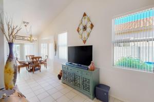 a living room with a television and a dining room at The CW Desert Oasis in Oro Valley