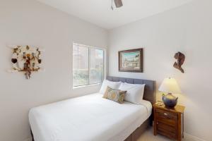 a white bedroom with a bed and a night stand at The CW Desert Oasis in Oro Valley