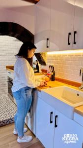 een vrouw die in een keuken staat om eten te bereiden bij Charming Country House in Altares