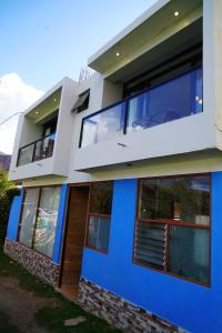 Cette maison bleue et blanche dispose d'un balcon. dans l'établissement PACHAMAMA ROOMS, à Urubamba