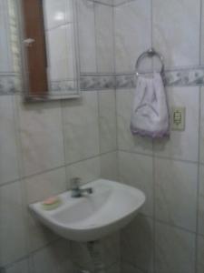 a bathroom with a sink and a towel on the wall at Casa em Cabo Frio in Cabo Frio