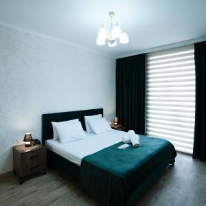 a bedroom with a large bed with a green blanket at Avrasya Hotel in Baku
