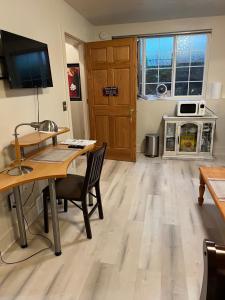 un salon avec une table, des chaises et une télévision dans l'établissement West Side Grand Rapids 2 room apartment close to everything, à Grand Rapids