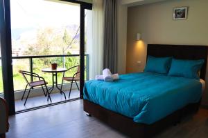 a bedroom with a bed and a balcony with a table at PACHAMAMA ROOMS in Urubamba