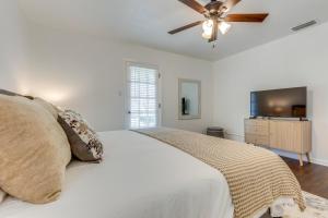 um quarto com uma cama branca e uma ventoinha de tecto em Family-Friendly Home 6 Mi to Downtown Mobile! em Mobile