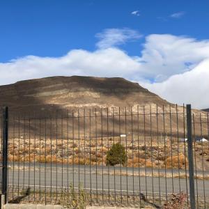 uma vista para uma montanha atrás de uma cerca em Femiba em El Calafate