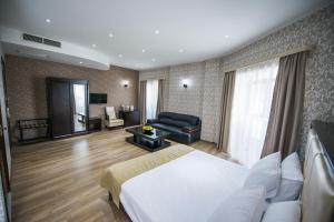 Habitación de hotel con cama y sala de estar. en Tbilisi Inn, en Tiflis