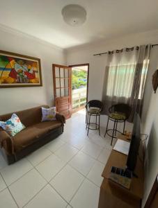a living room with a couch and a tv at Apartamento em Ilha De Itamaracá in Vila Velha