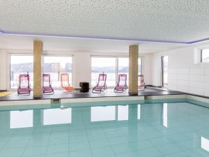 - une piscine avec des chaises rouges dans la chambre dans l'établissement Lärchenhof Top 01, à Mauterndorf