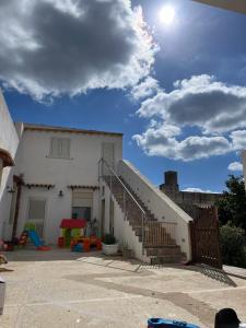 una casa blanca con escaleras y un cielo azul en Casa Farinelli, en Campobello di Mazara