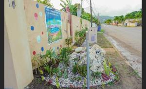 un compteur de stationnement à côté d'un mur avec un jardin de rochers dans l'établissement A taste of Jamaica Lavern’s Place, à Ocho Rios
