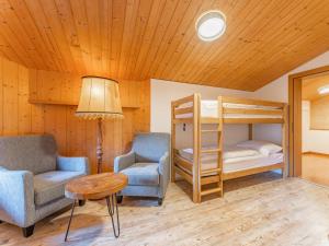 Spykerhütte في راوريس: غرفة معيشة مع سرير بطابقين وكرسي وطاولة