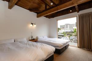2 camas en una habitación con ventana grande en 貸別荘 楓-Fū- 有馬, en Arima