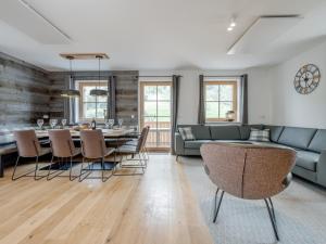 a living room with a couch and a table and chairs at Vita Montagna in Donnersbachwald