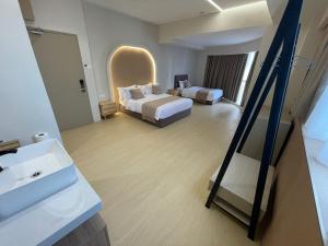 baño con 2 camas, lavabo y espejo en Stanton Gaya Hotel, en Kota Kinabalu