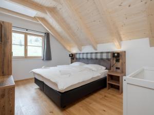 a bedroom with a large bed and wooden ceilings at Vita Montagna in Donnersbachwald