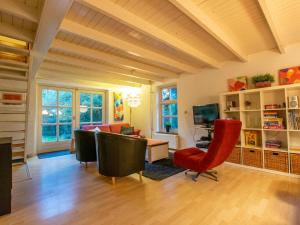 een woonkamer met een bank en stoelen en een tv bij Broeksteeg in Haaren