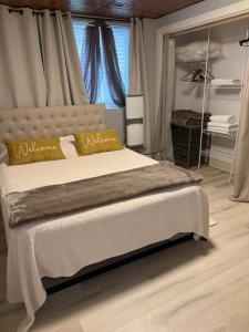 une chambre avec un lit avec des oreillers jaunes et une fenêtre dans l'établissement West Side Grand Rapids 2 room apartment close to everything, à Grand Rapids