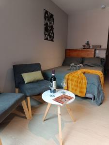 a bedroom with a bed and a table with a bottle of wine at Casa Juanito Coworking El Nogal in Zona Rosa in Bogotá