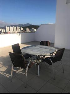 una mesa y sillas en la azotea en Apartamento Deep Blue, en Balneário Camboriú