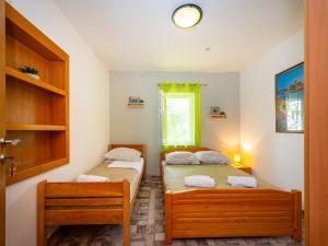 two twin beds in a room with a window at Apartments with a parking space Nin, Zadar - 10414 in Nin