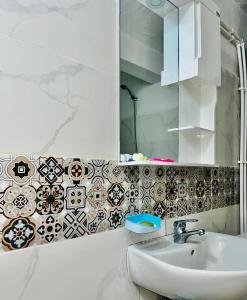 ein Bad mit einem Waschbecken und einem Spiegel in der Unterkunft Hostel le Rhumel in Constantine