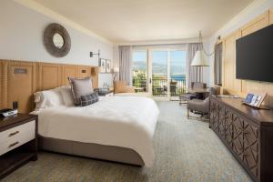 Terranea Resort في رانتشو بالوس فيرديس: غرفه فندقيه سرير كبير وتلفزيون