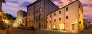 un edificio con coches estacionados en una calle por la noche en Palazzo Ruschioni Boutique Hotel, en Camerano