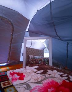 a bedroom with a bed in a blue tent at Luxury tent in the middle of nature 