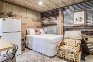 a bedroom with a bed and a refrigerator and a chair at Casas Coastal Experience Cabin C in Rockport