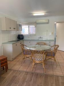 a kitchen with a table and chairs in a kitchen at Beachfront at Silver Sands Hervey Bay in Hervey Bay