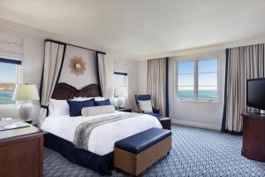 Terranea Resort في رانتشو بالوس فيرديس: غرفه فندقيه سرير كبير وتلفزيون