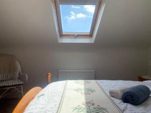 a bedroom with a bed with a window at Ivy Lane in Loughanure