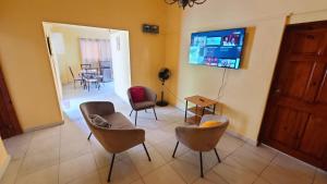 a living room with chairs and a flat screen tv at Super Two Bedroom Penthouse in Peguy-Ville in Port-au-Prince