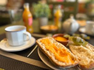 Posada La Fragua في Gandullas: قطعتين من الخبز المحمص على طاولة مع كوب من القهوة