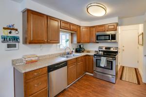 una cocina con armarios de madera y electrodomésticos de acero inoxidable en Cozy Anchorage Retreat Less Than 4 Mi to Downtown!, en Anchorage