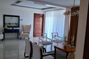 Appartamento Sidney في سان فيرناندو دو مونتي كريستي: غرفة معيشة مع كراسي وطاولة
