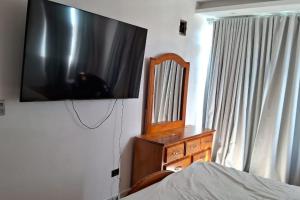 a television hanging on a wall in a bedroom at Appartamento Sidney in San Fernando de Monte Cristi