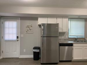 uma cozinha com um frigorífico de aço inoxidável e armários brancos em Rooms with a Mountain View em Pleasant Grove