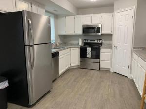a kitchen with white cabinets and a stainless steel refrigerator at Rooms with a Mountain View in Pleasant Grove +27 photos