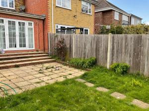 a fence in front of a house with a yard at Stunning 4-Bed House in Rochester in Rochester