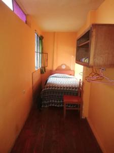 a small room with a bed and a window at Hospedaje Frankenstein in Cusco