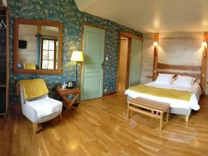 a bedroom with a bed and a chair at Chambre familiale au cœur de la nature avec jardin et piscine privée, idéale pour explorer le Loiret - FR-1-590-265 in Vitry-aux-Loges +14 photos