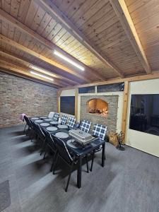 ヴコヴァルにあるHoliday house with a parking space Vukovar, Slavonija - 22809のテーブルと椅子、暖炉が備わる広い客室です。