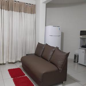 d'un salon avec un canapé brun et un réfrigérateur. dans l'établissement Apartamento Inteiro Iguaçu Ipatinga, à Ipatinga