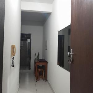 un couloir avec un téléphone sur le mur et une table dans l'établissement Apartamento Inteiro Iguaçu Ipatinga, à Ipatinga