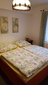 a bedroom with a bed with a floral bedspread at Ferienwohnung am Bloschk in Schwielochsee