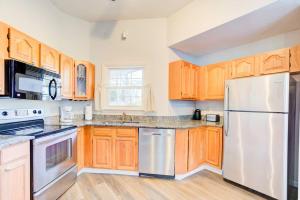a kitchen with wooden cabinets and stainless steel appliances at Top Choice Family Vacation House Walkable to Shops in Cary