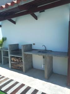 uma cozinha exterior com um lavatório e uma mesa em Casa Wadara em La Mira