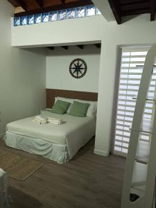 1 dormitorio con 1 cama con reloj en la pared en Casa Wadara en La Mira